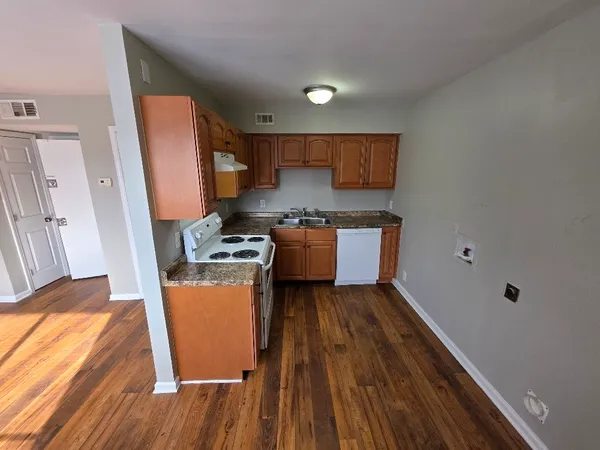a kitchen with wooden floors and a sink