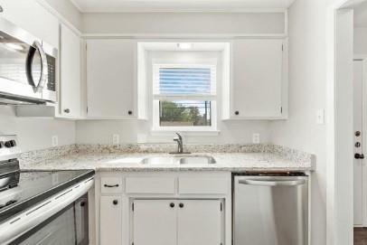 7700 Chapin Road, Unit 7 Fort Worth, TX 76116 - Photo 3 of 13 Kitchen featuring white cabinetry, light-toned countertops, a stainless steel microwave, and a stainless steel dishwasher
