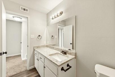 7700 Chapin Road, Unit 7 Fort Worth, TX 76116 - Photo 6 of 13 Bathroom vanity featuring a single basin, stone-finish countertop, and white cabinetry