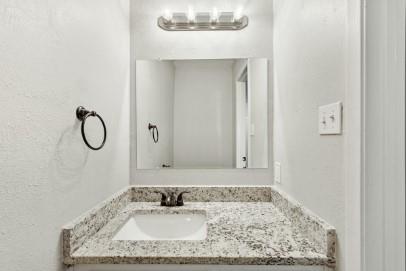 7700 Chapin Road, Unit 7 Fort Worth, TX 76116 - Photo 8 of 13 Bathroom vanity featuring a speckled countertop, integrated sink, and dark bronze faucet
