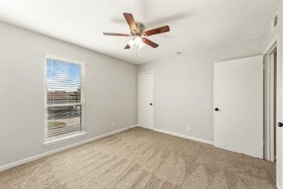 7700 Chapin Road, Unit 7 Fort Worth, TX 76116 - Photo 10 of 13 Carpeted room featuring a ceiling fan with light fixture, window with blinds, and white interior doors with black hardware