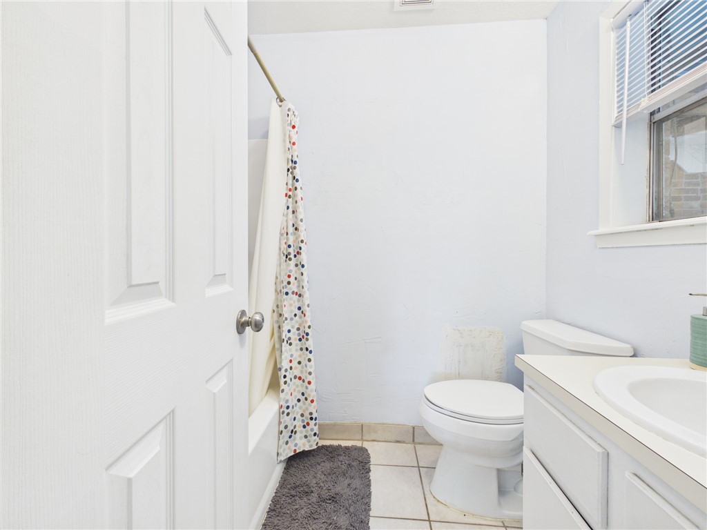 800 Rio Grande Lane Bryan, TX 77801 - Photo 16 of 23 a white toilet sitting next to a shower curtain