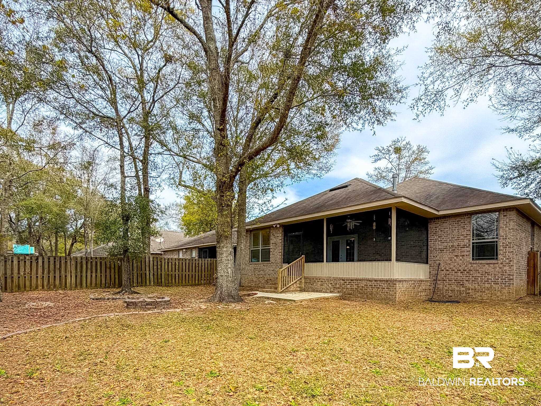 7332 Raintree Lane Gulf Shores, AL 36542 - Photo 20 of 21 Rear view of house with brick siding and a patio area
