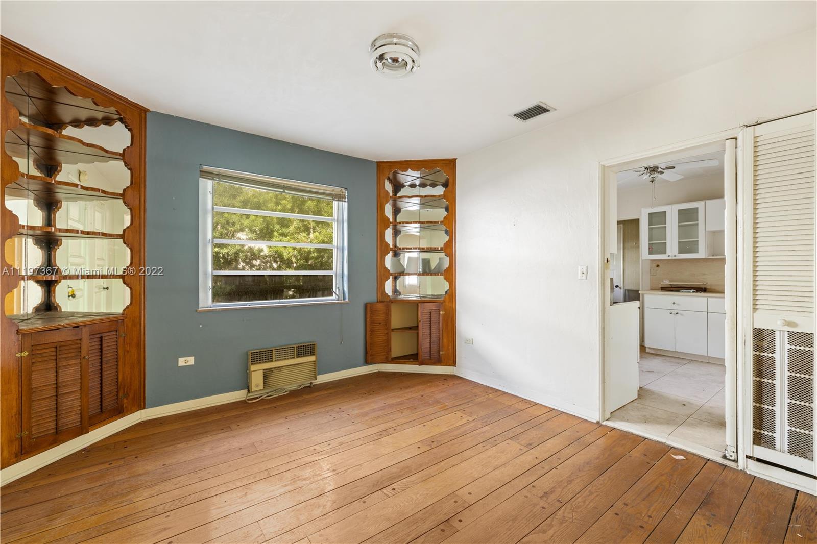 531 Northeast 55th Terrace Miami, FL 33137 - Photo 13 of 22 a view of an empty room with wooden floor and a window