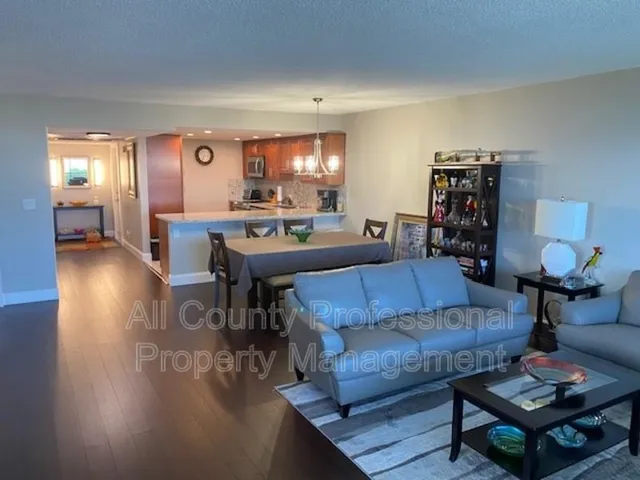 a living room with furniture a lamp and wooden floor
