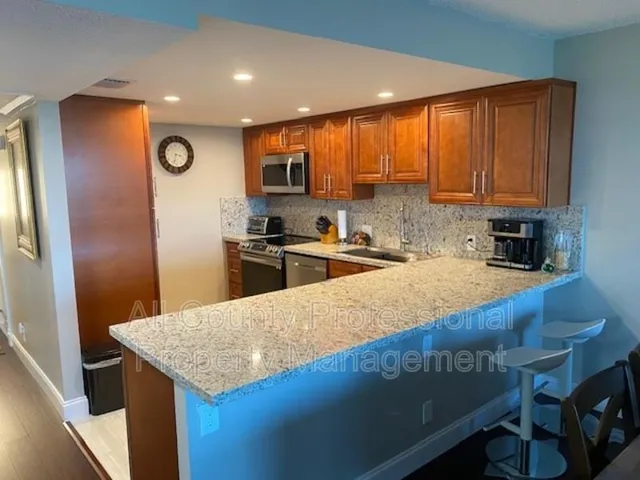 a kitchen with granite countertop a sink stainless steel appliances and cabinets