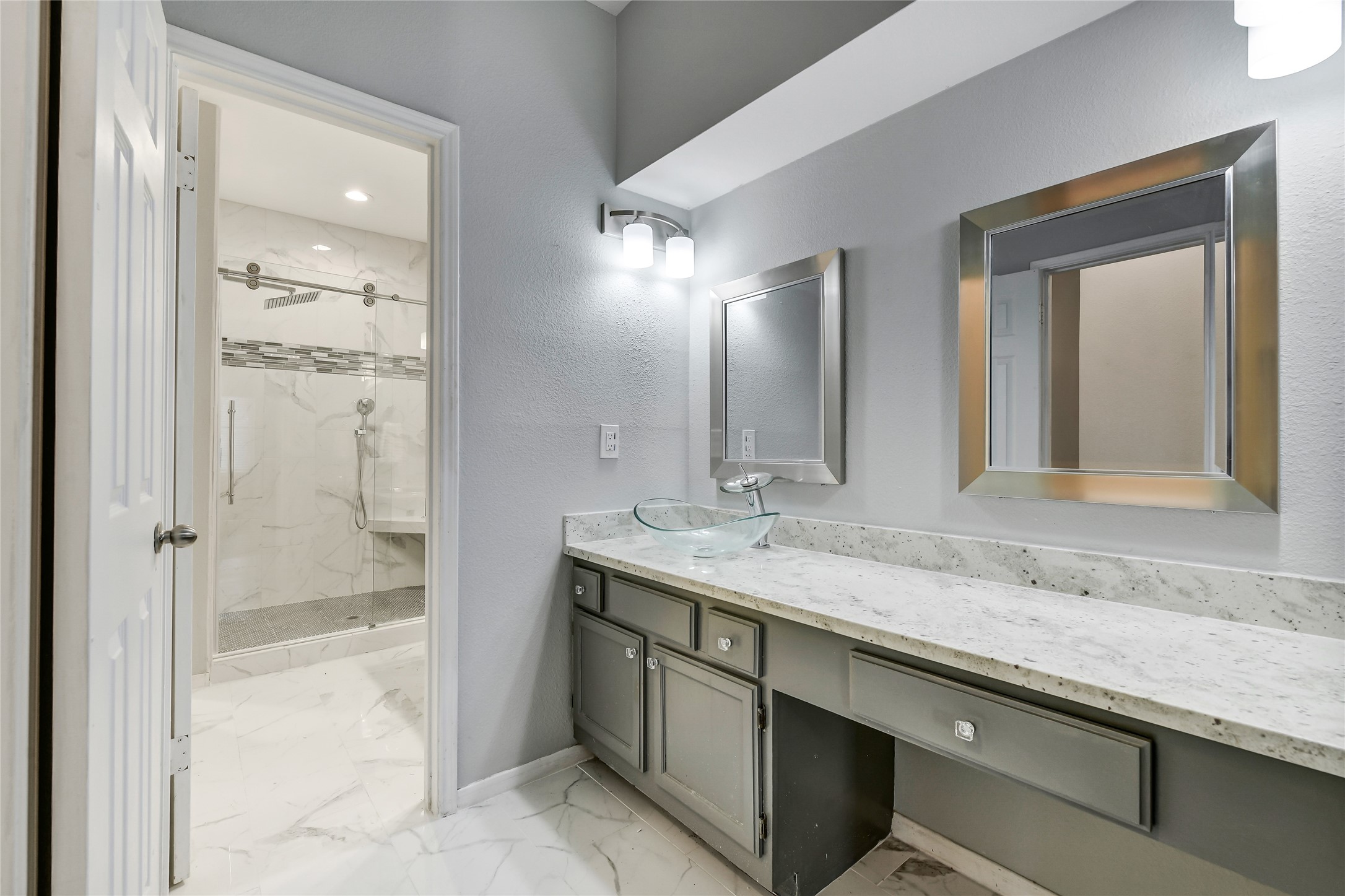 4001 Tanglewilde Street, Unit 1402 Houston, TX 77063 - Photo 14 of 23 Discover the fully renovated primary bath, boasting a sleek single sink, ample storage, a cozy vanity area, a spacious walk-in closet, and a luxurious spa-like shower for a rejuvenating retreat.