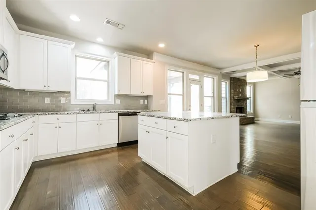 a kitchen with granite countertop white cabinets and white appliances