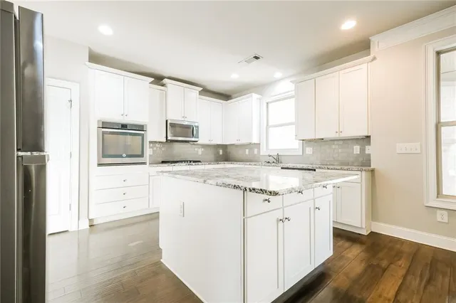 a kitchen with granite countertop white cabinets and white appliances
