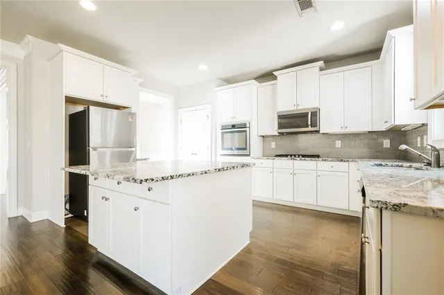 a kitchen with stainless steel appliances a refrigerator sink and microwave