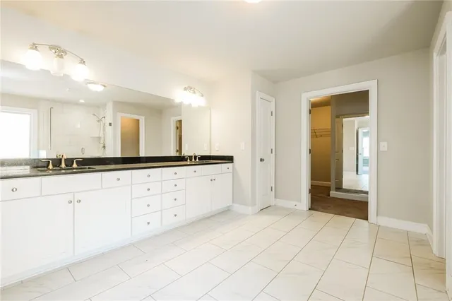 a spacious bathroom with a granite countertop sink and a mirror
