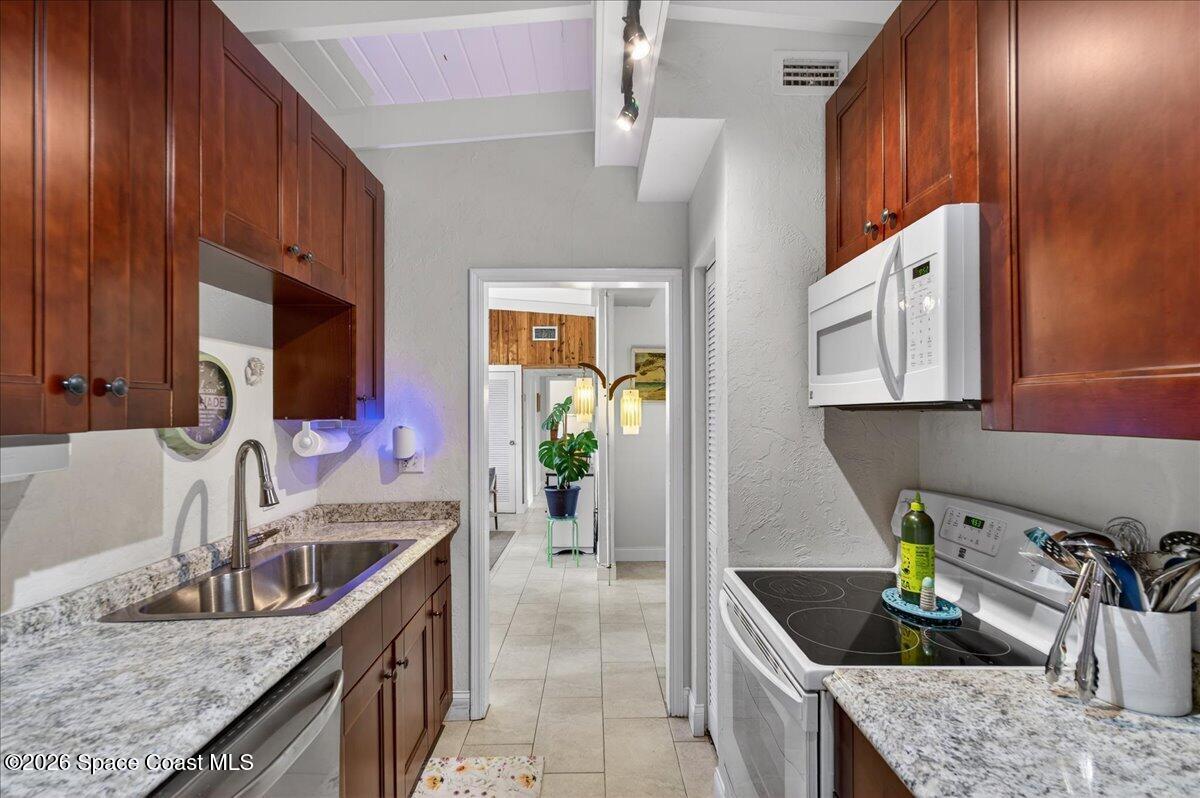 1615 Grandview Way Melbourne, FL 32935 - Photo 12 of 34 a kitchen with stainless steel appliances granite countertop a sink a stove and a wooden cabinets