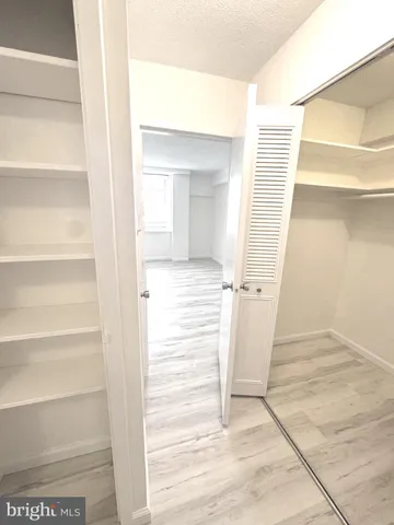 a view of a room with wooden floor and entryway