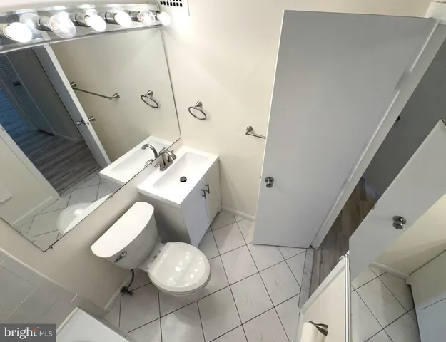 a view of a hallway with wooden floor and cabinet