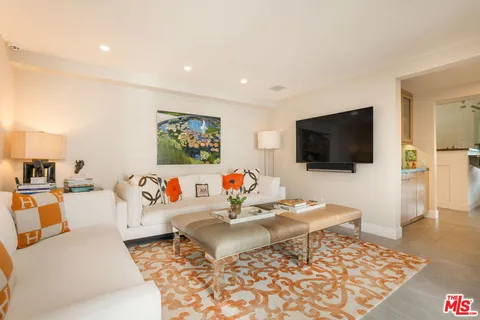 a view of a hallway with wooden floor and a bathroom