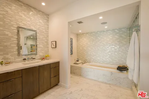 a bathroom with a bathtub shower sink and a toilet