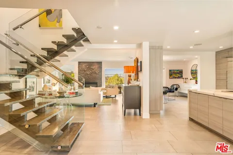 a living room with fireplace furniture and a large window