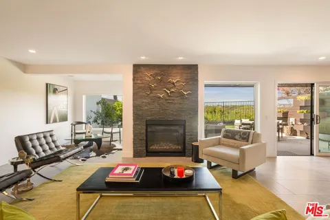 a living room with furniture and a floor to ceiling window