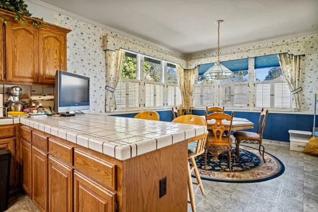 a kitchen with a appliances a counter space and a view of living room
