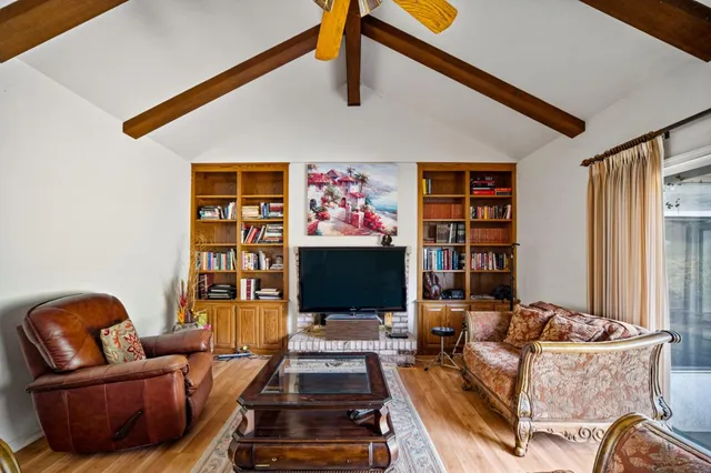 a living room with furniture workspace and a flat screen tv