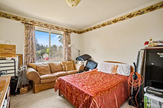 a bedroom with a bed couch and a window