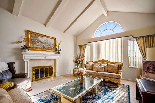a living room with furniture a fireplace and a large window