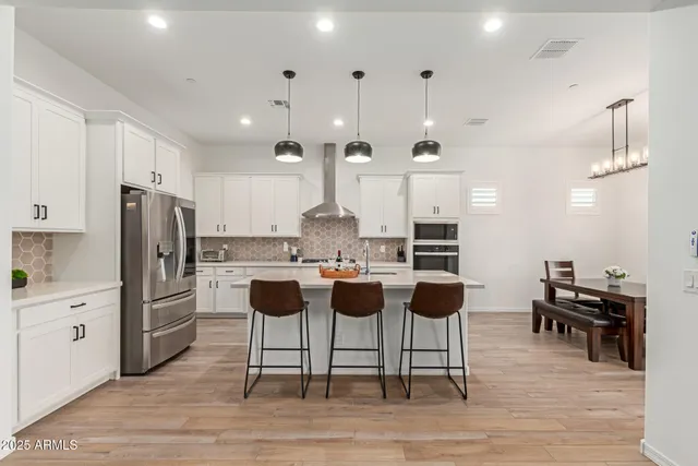 a living room with furniture and a large window with potted plants