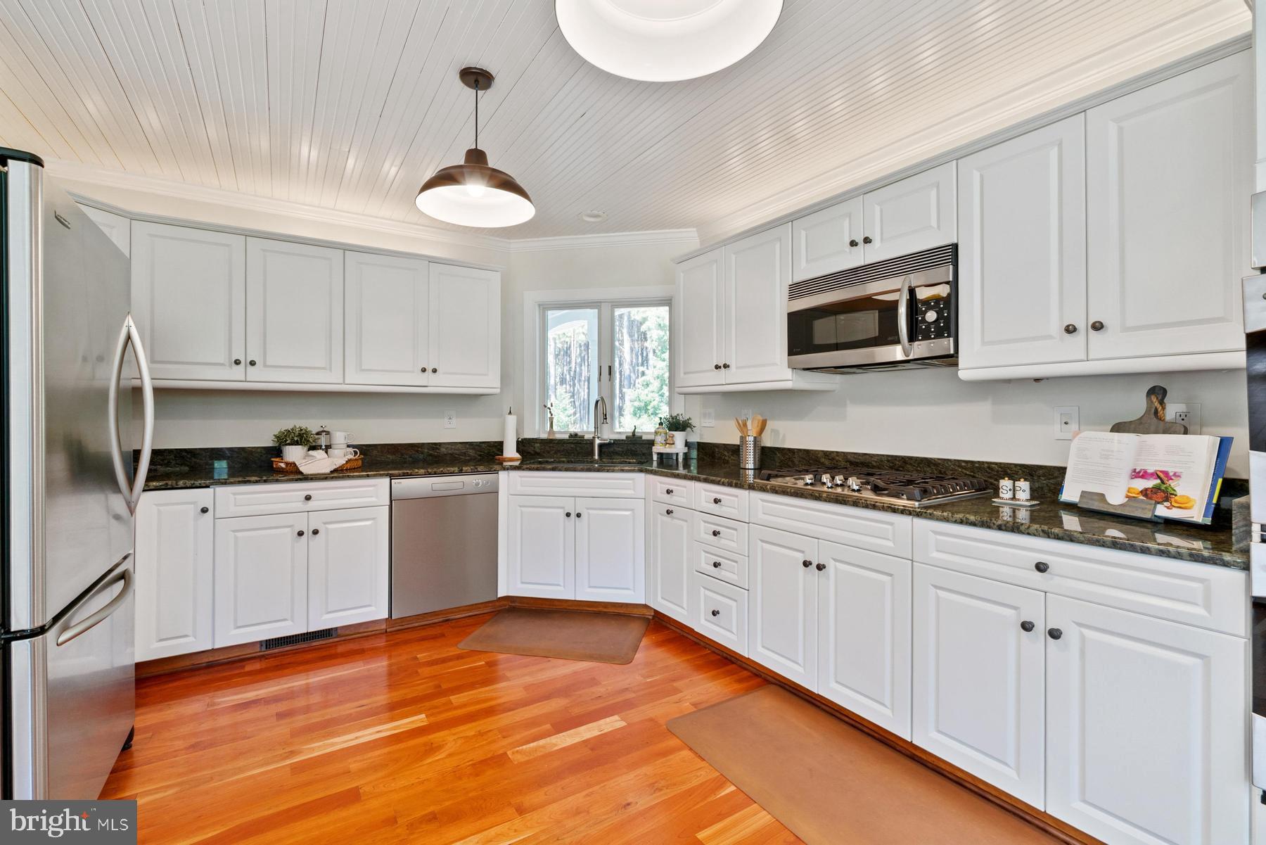 8095 Church Neck Road St. Michaels, MD 21663 - Photo 18 of 48 a kitchen with granite countertop white cabinets white stainless steel appliances and a sink