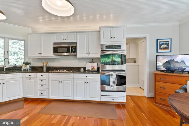 a kitchen with cabinets stainless steel appliances and a window