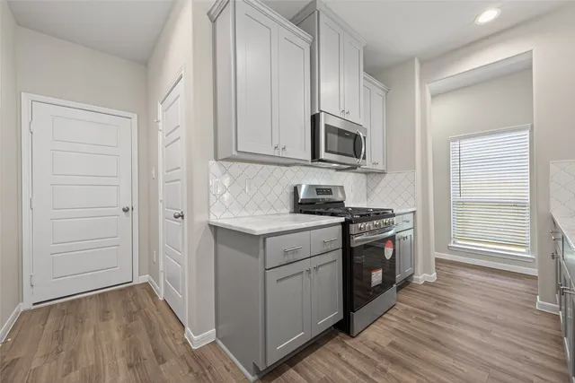 a kitchen with kitchen island granite countertop a sink cabinets and wooden floor