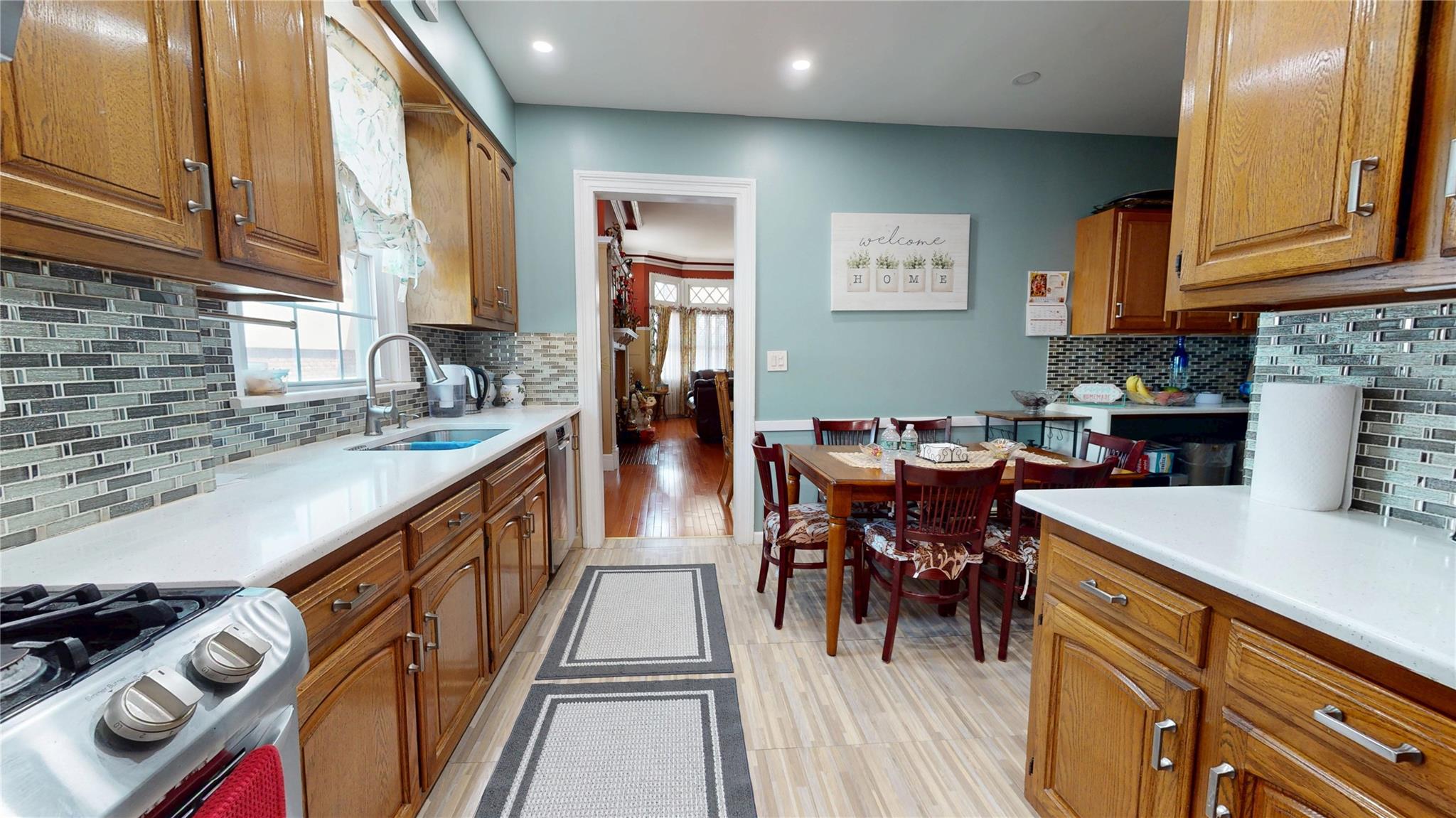 31-06 Healy Avenue Queens, NY 11691 - Photo 11 of 34 Kitchen with brown cabinetry, tasteful backsplash, gas stove, and a sink