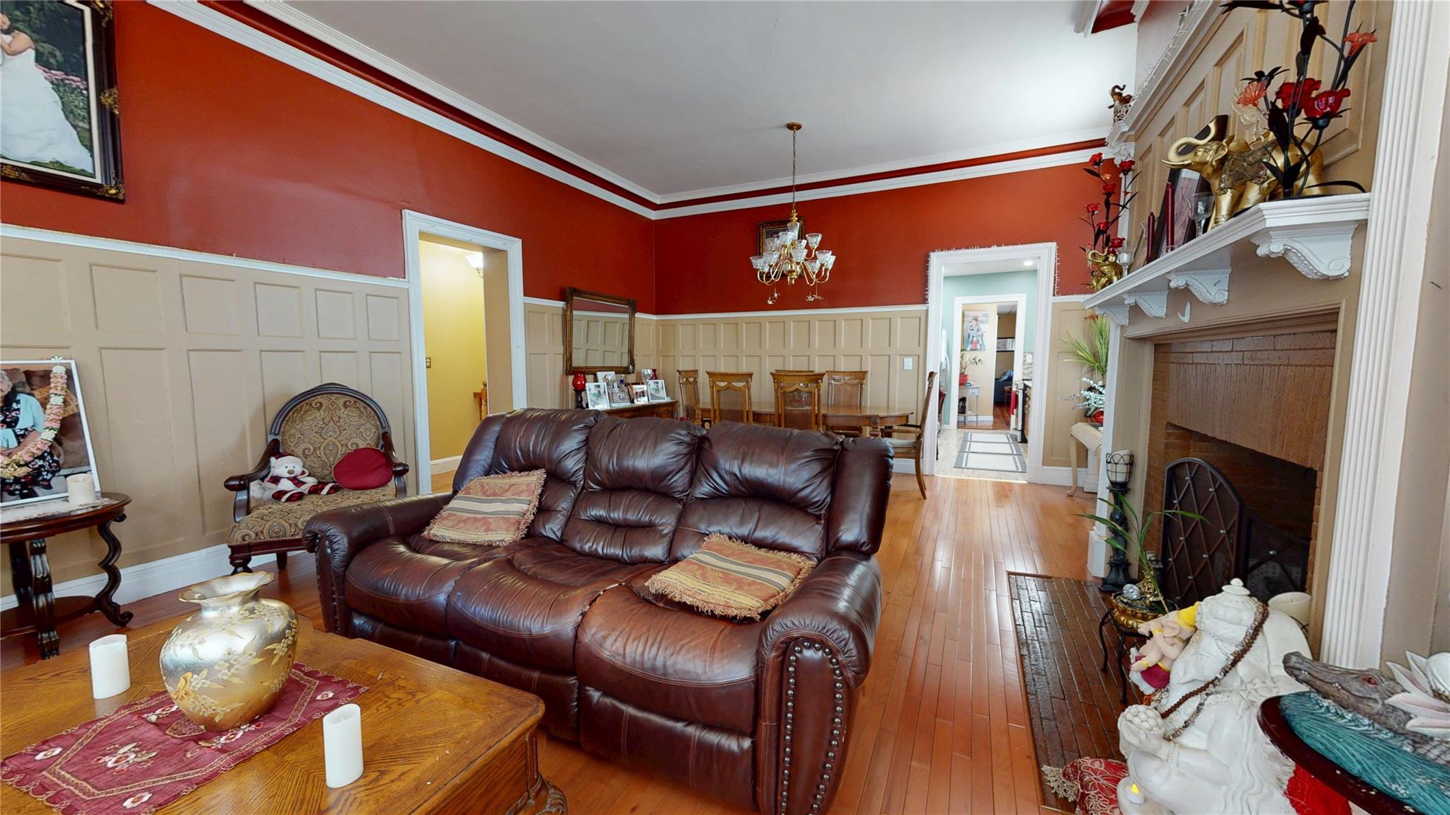 31-06 Healy Avenue Queens, NY 11691 - Photo 8 of 34 Living area with a chandelier, a fireplace, a decorative wall, ornamental molding, and hardwood / wood-style floors