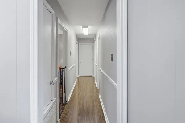 a view of a hallway with wooden floor and staircase