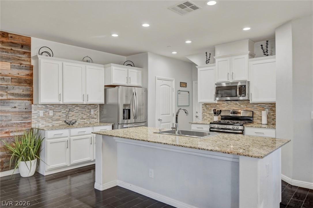 48 Jasmine Point Street Henderson, NV 89074 - Photo 22 of 62 A well-appointed kitchen features a large island with sink and stainless steel appliances.