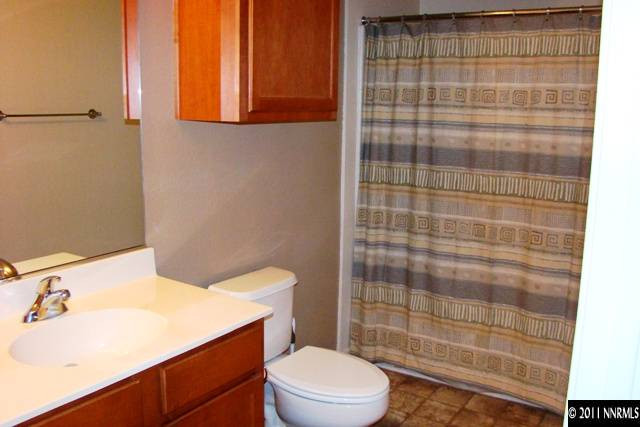 9050 Double R Boulevard, Unit 711 Reno, NV 89521 - Photo 9 of 13 a bathroom with a sink a toilet and shower