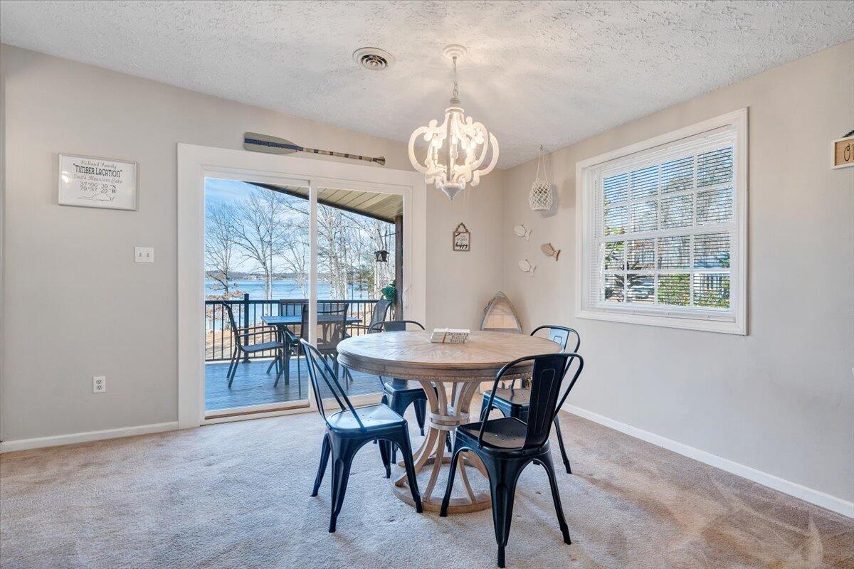 1111 Jefferson Dock Road Penhook, VA 24137 - Photo 18 of 50 a view of a dining room with furniture a chandelier and wooden floor