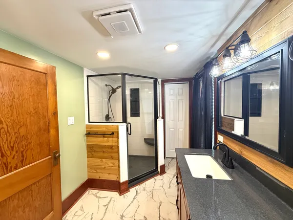 a bathroom with a tub shower and sink