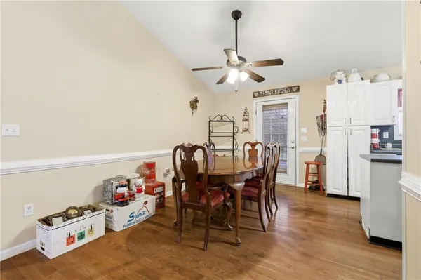 a view of a dining room and livingroom with furniture wooden floor a chandelier