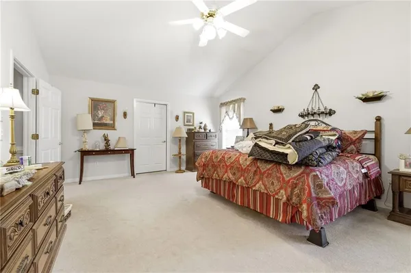 a spacious bedroom with a bed and a chandelier