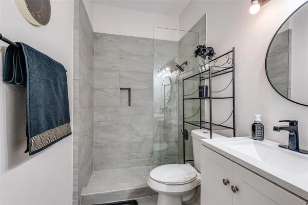 a bathroom with a sink a toilet and shower