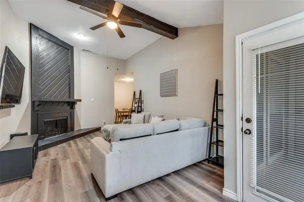 a living room with furniture a fireplace and a flat screen tv