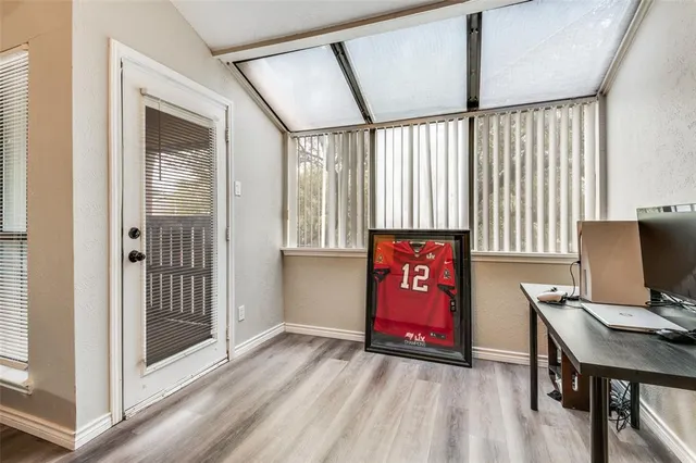 a view of an empty room with window wooden floor