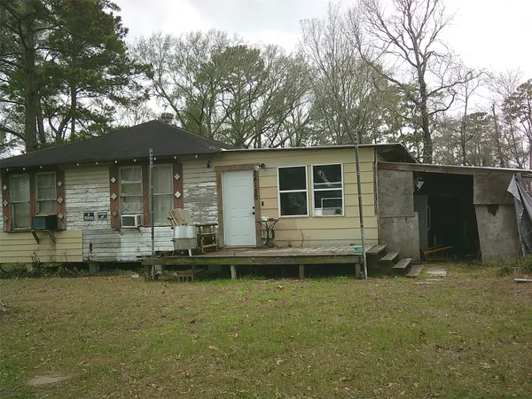 a backyard of a house with barbeque oven and table