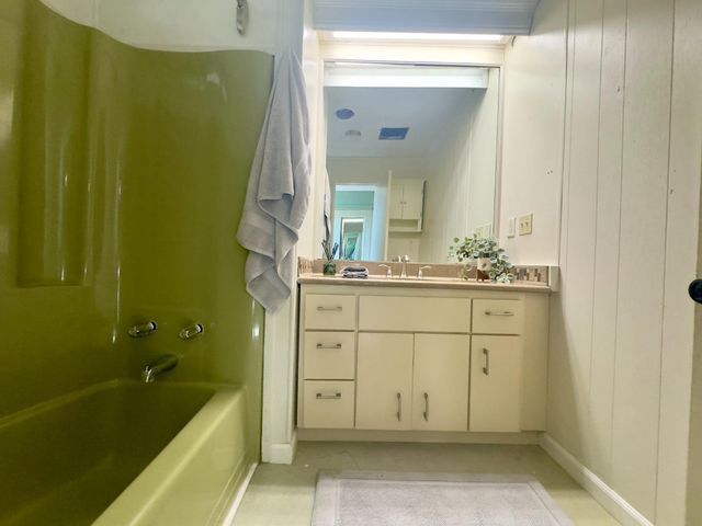 a bathroom with a bathtub sink and mirror