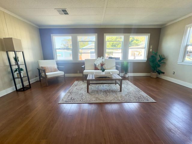a living room with furniture and a hard wood floor