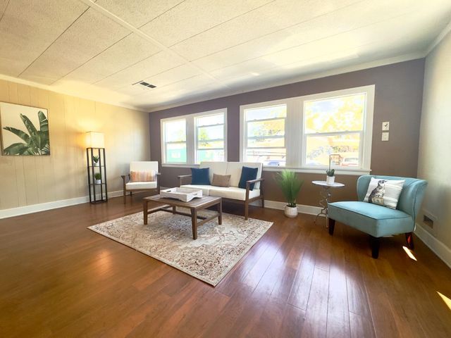 a living room with furniture and a wooden floor