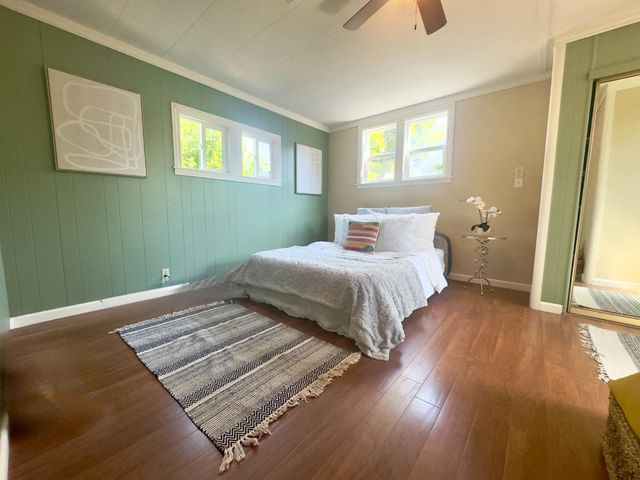 a bedroom with a bed and wooden floor