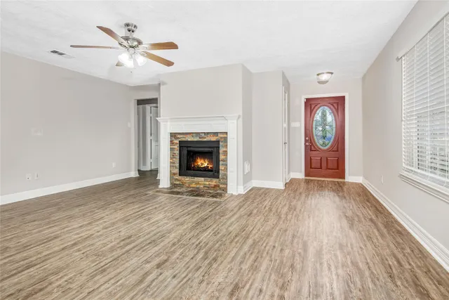 an empty room with windows fireplace and a sink