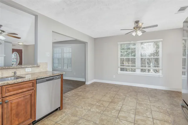 a view of a kitchen with granite countertop cabinets a sink a window and stainless steel appliances