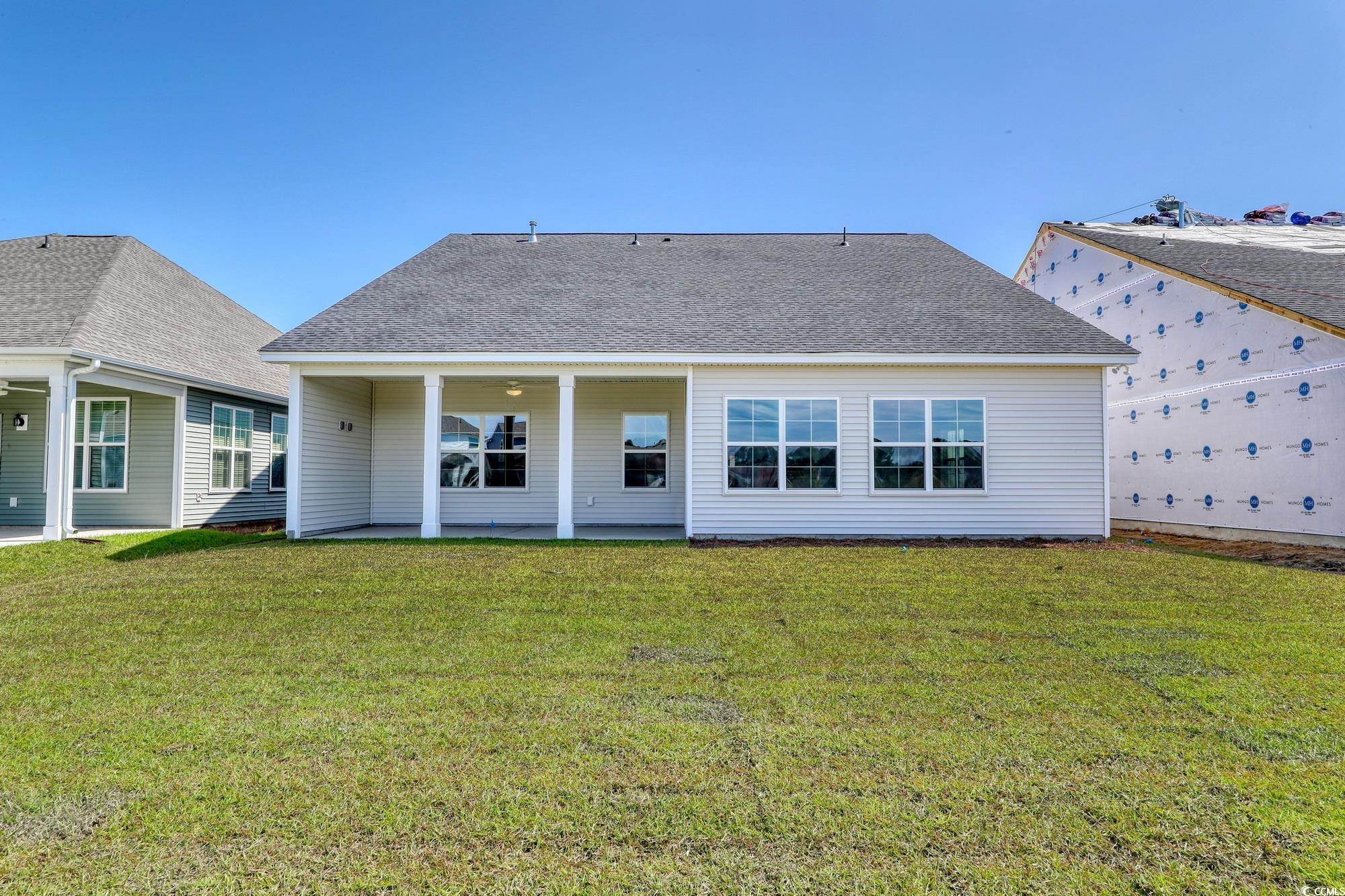 4028 Bucolic Loop Myrtle Beach, SC 29588 - Photo 29 of 40 Back of house with a patio, a lawn, and roof with